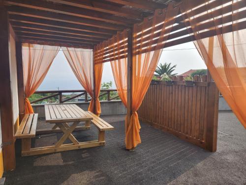 UrzelinaLucy's Rosegarden的阳台配有橙色窗帘和长凳