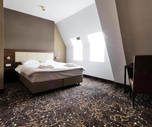 巴德胡弗多普Amsterdam Lake Hotel的一间卧室设有一张大床和一个窗户。