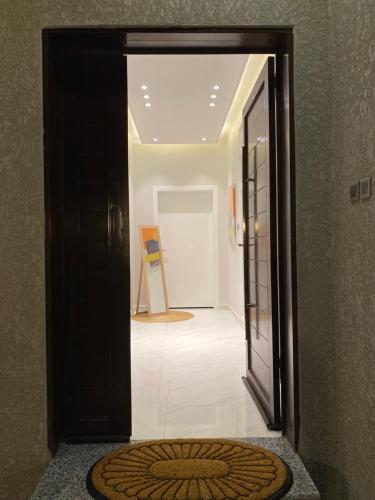 艾卜哈جناح فندقي في فله خاصة的通往带椅子的走廊的开放式门