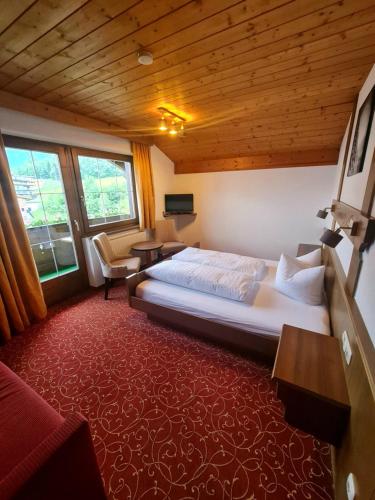 拉迪斯Haus Gabriele的一间带一张大床的卧室,位于一个拥有木制天花板的房间