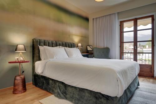 约阿尼纳Harmony villa - Ioannina castle的一间卧室设有一张大床和一个窗户。