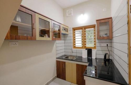 维特利Greenfield Homestay的厨房配有木制橱柜和黑色台面