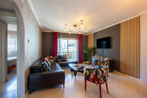 米哈斯Maravilloso Apartamento en Mijas Golf的客厅配有黑色真皮沙发和椅子