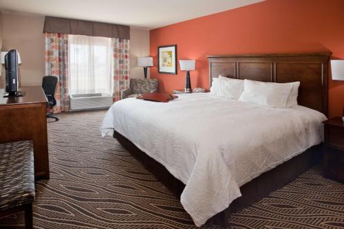 布莱斯维尔布莱斯维尔汉普顿酒店的酒店客房设有一张大床和一张书桌。