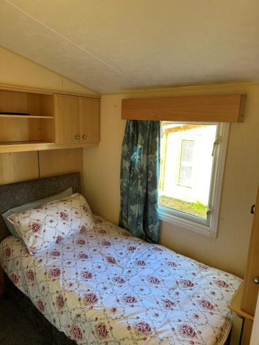 普里茅斯Static Caravan - Plymouth - Costal Location的一间小卧室,配有床和窗户
