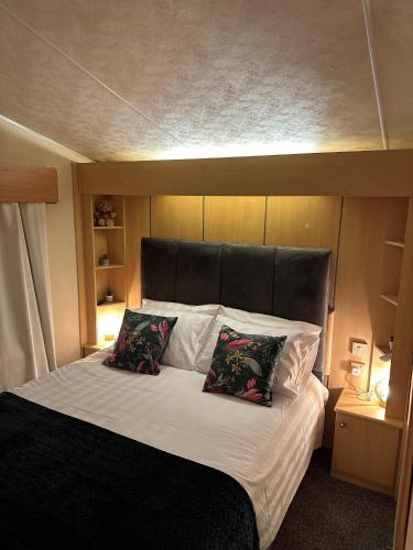 普里茅斯Static Caravan - Plymouth - Costal Location的一张带黑色床头板的床和两个枕头