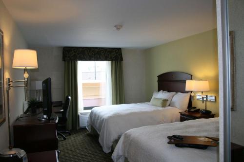 门托克利夫兰门托希尔顿恒庭旅馆&套房酒店的酒店客房设有两张床和窗户。