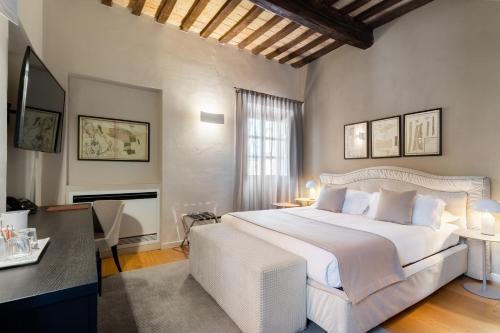 卡内利Relais Villa del Borgo的卧室配有一张白色大床和一张书桌
