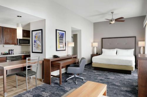 尚佩恩霍姆伍香槟-乌尔班纳酒店的酒店客房带一张床铺、一张书桌和一间卧室