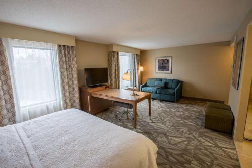 蒂尔顿蒂尔顿汉普顿套房酒店的酒店客房配有一张床、一张书桌和一张沙发。