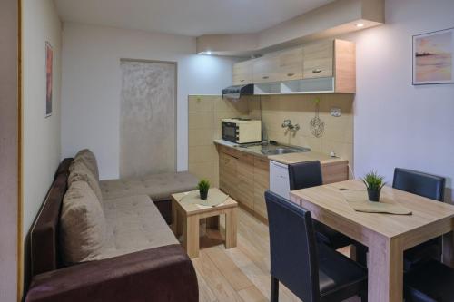 索科矿泉村Apartmani Tvins的客厅以及带沙发和桌子的厨房。