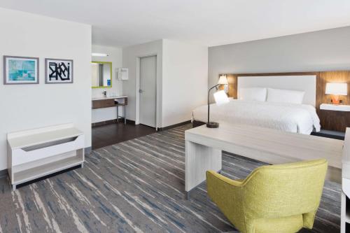 凤凰城凤凰城哥伦布区希尔顿恒庭旅馆&套房酒店的配有一张床和一张书桌的酒店客房