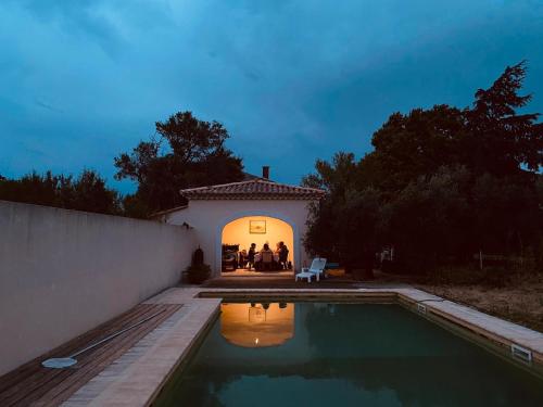叙兹拉鲁斯Studio calme dans les vignes的一群人晚上站在游泳池附近