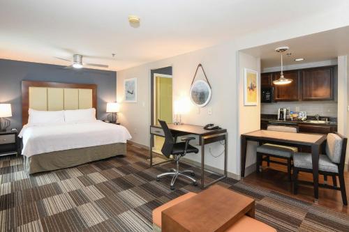 弗洛伦斯南佛罗伦萨辛辛那提机场希尔顿惠庭套房酒店的酒店客房配有一张床、一张书桌和一间厨房。