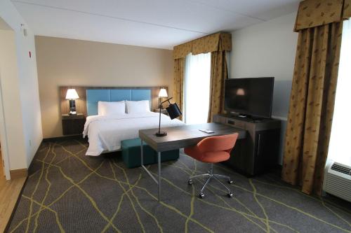 弗拉格勒海滩汉普顿酒店及套房棕榈海岸的酒店客房配有一张床、一张书桌和一台电视。
