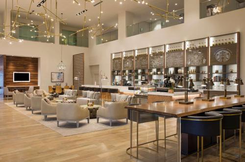 达拉斯达拉斯 - 爱田希尔顿逸林酒店的餐厅设有酒吧,配有桌椅