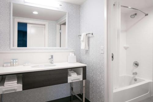 迪比克汉普顿迪比克酒店的一间带水槽、浴缸和镜子的浴室