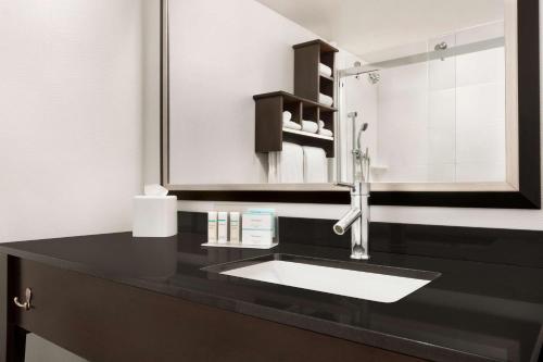 高尔顿单沃西金汉普顿酒店的一间带水槽和镜子的浴室