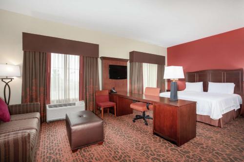 隆娜特里丹佛/南瑞吉盖特汉普顿酒店的配有一张床和一张书桌的酒店客房
