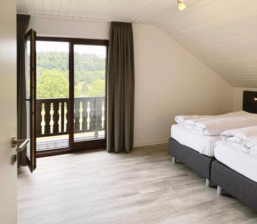 锡默拉特Ferienpark Rursee的一间卧室设有两张床和大窗户