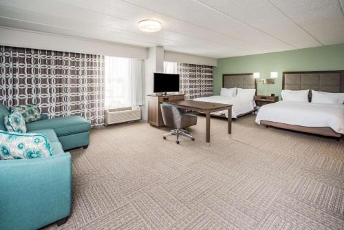 多佛尔多佛尔汉普顿酒店的酒店客房带两张床、一张桌子和一张沙发