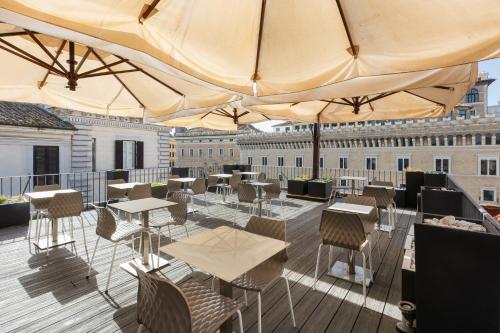 罗马Hotel Castellino Roma的一个带桌椅和遮阳伞的屋顶露台