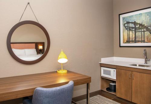 伊利Hampton Inn Erie-South的浴室设有一张带水槽和镜子的书桌