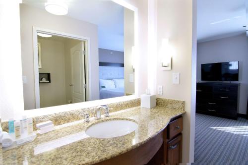 法戈法戈希尔顿惠庭套房酒店的一间带水槽和大镜子的浴室
