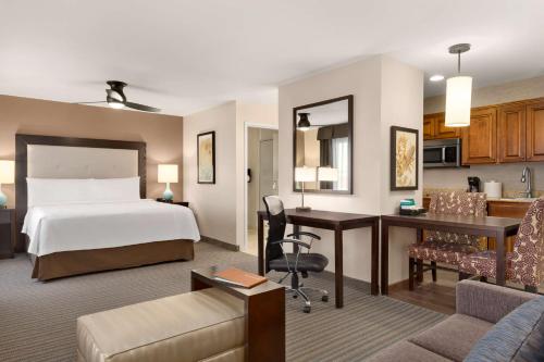 法戈法戈希尔顿惠庭套房酒店的配有一张床和一张书桌的酒店客房
