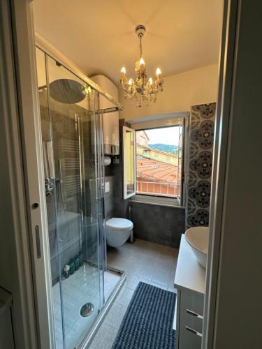 莱里奇Delizioso bilocale Mottino23的带淋浴和卫生间的浴室以及吊灯。