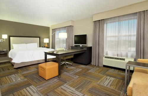 弗洛伦斯佛罗伦萨市区汉普顿套房酒店的配有一张床和一张书桌的酒店客房