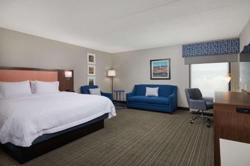 费尔法克斯费尔法克斯市汉普顿旅馆的酒店客房,配有床和蓝色椅子