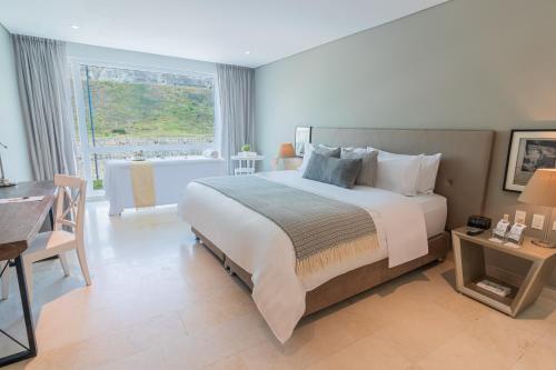 卡塔赫纳GHL San Lazaro Art Hotel的一间卧室配有一张大床、一张桌子和一个浴缸