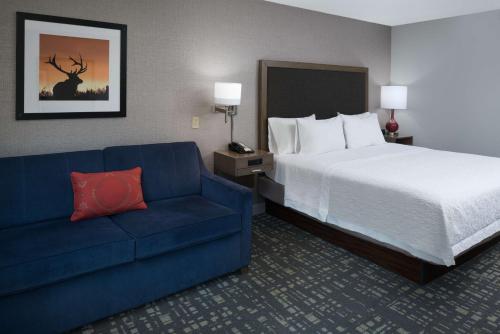 North Sioux City北苏城汉普顿酒店的酒店客房,配有床和蓝色的沙发