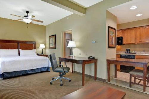 费耶特维尔费耶特维尔希尔顿家木套房酒店的酒店客房配有一张床、一张书桌和一间厨房。