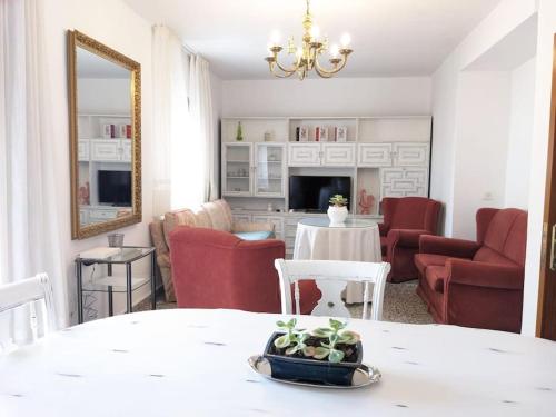 马贝拉Luminosa casa familiar céntrica的客厅配有桌子和红色椅子