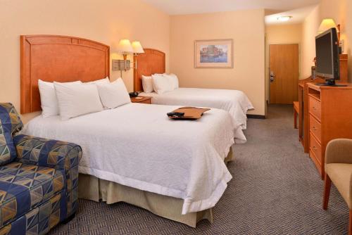 格兰德岛格兰德岛汉普顿酒店的酒店客房,配有两张床和椅子
