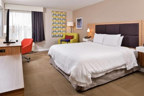 McLeansville格林斯伯罗东/麦克莱恩斯维尔汉普顿酒店的酒店客房带一张大床和两张椅子