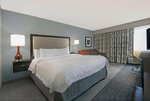 格林维尔格林维尔/伍德拉夫路汉普顿酒店的酒店客房带一张大床和一把椅子