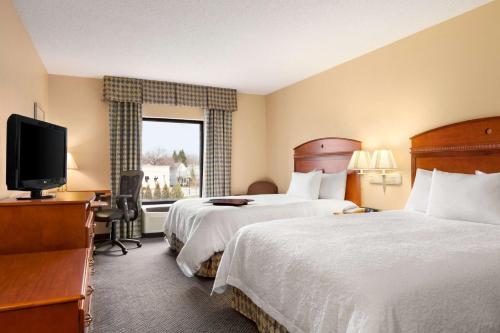 日内瓦纽约州汉普顿日内瓦酒店的酒店客房设有两张床和电视。