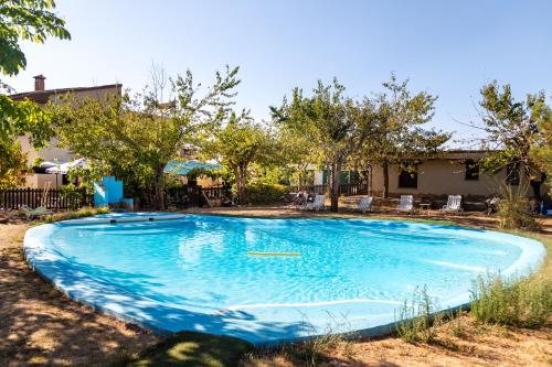 圭哈尔谢拉Hotel Rural Fuente La Teja的一座种植了树木的庭院里的大型蓝色游泳池