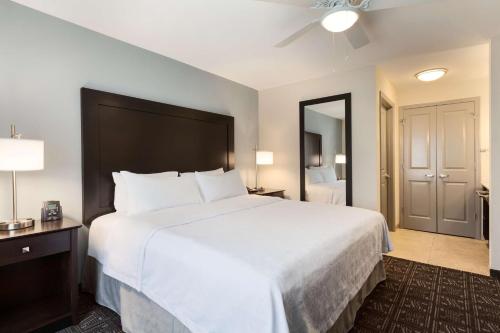 亨茨维尔亨茨维尔中心希尔顿惠庭套房酒店的酒店客房设有一张白色大床和镜子