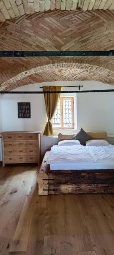 班斯卡比斯特里察Šilarjeva huba Apartment的一间卧室设有一张带木制天花板的大床
