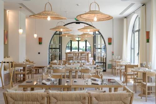 曼讷Le Couvent des Minimes Hôtel & Spa L'Occitane的餐厅设有桌椅和窗户。