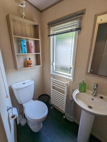 韦茅斯Littlesea Caravan on a Fabulous elevated position Haven Weymouth的一间带卫生间、水槽和窗户的浴室