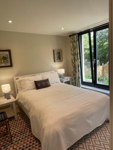 巴斯Garden hideaway, self-contained, edge of Bath的一间卧室设有一张大床和一个大窗户