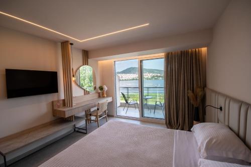 卡斯托里亚帕拉利姆尼奥套房旅馆的一间卧室配有一张床、一台电视和一个阳台
