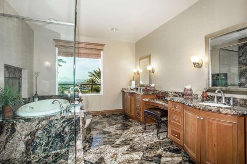 拉斯维加斯南拉斯维加斯希尔顿惠庭套房酒店的浴室配有2个盥洗盆、浴缸和淋浴。
