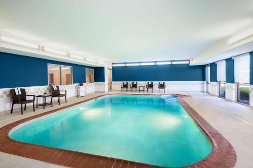 列克星敦南列克星敦希尔顿恒庭酒店的游泳池位于酒店客房内,配有椅子和桌子
