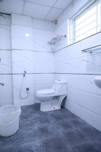 班加罗尔Western Keys Hotel的白色的浴室设有卫生间和水槽。